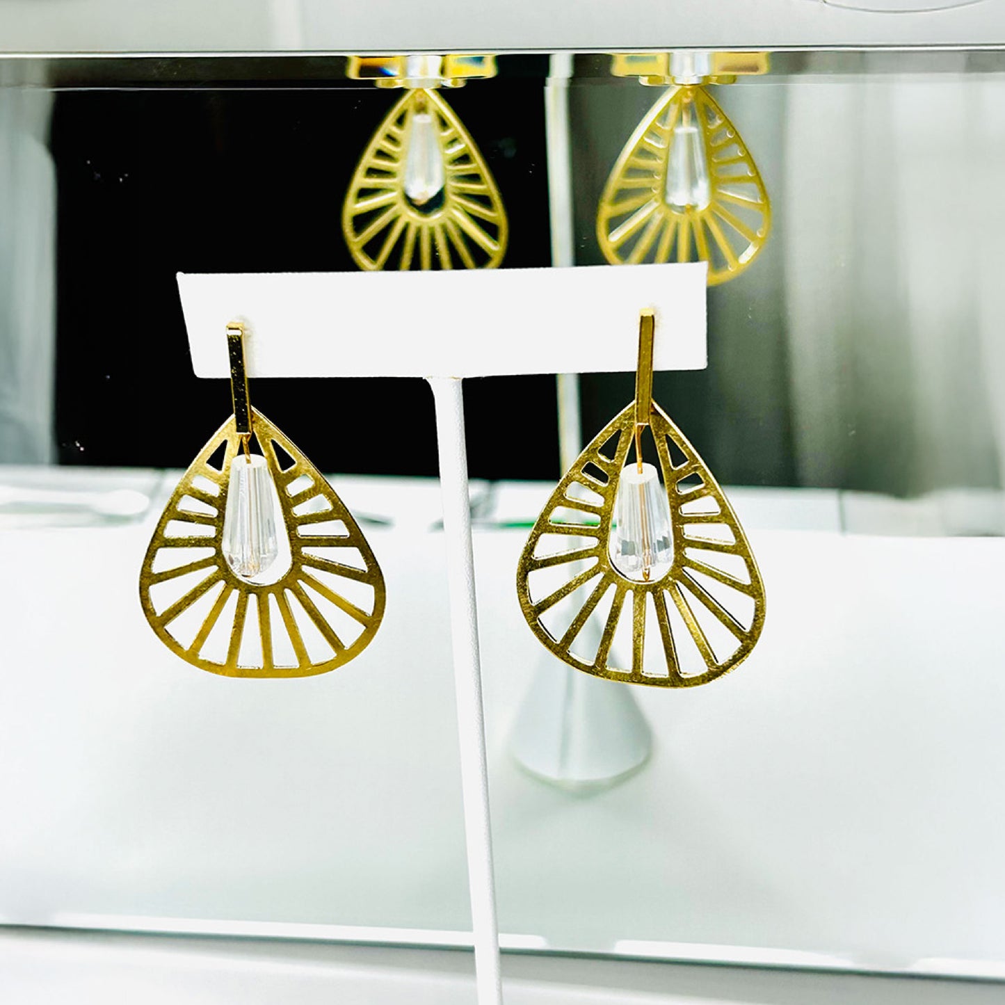 Fashion geometrical gold earrings with crystal at the center.