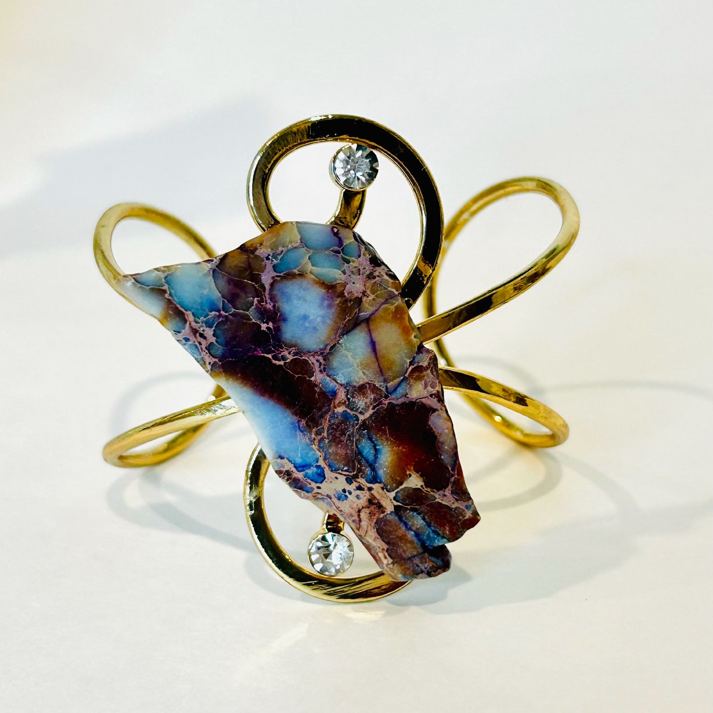 Fashion Twisted cuff gold bracelet with a bluish brown stone.