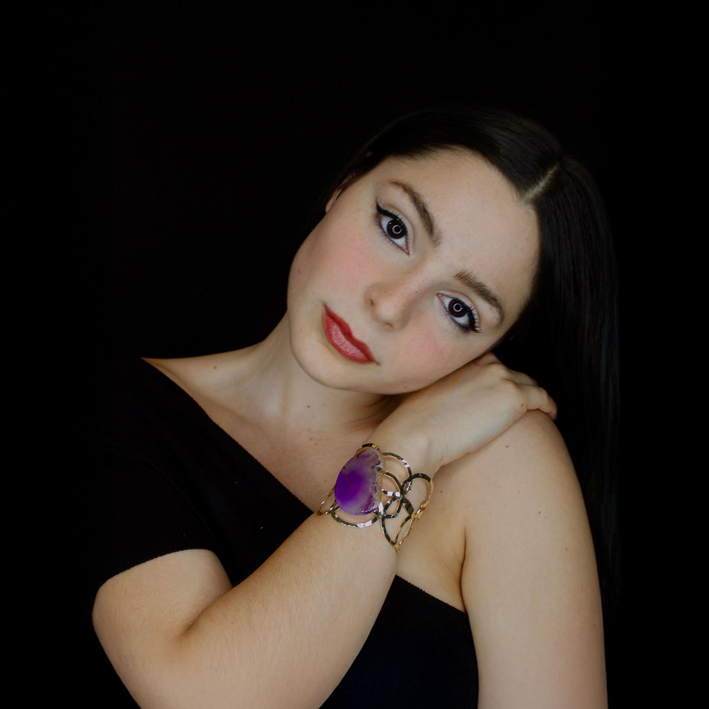 Gold fashion cuff bracelet with a purple stone.